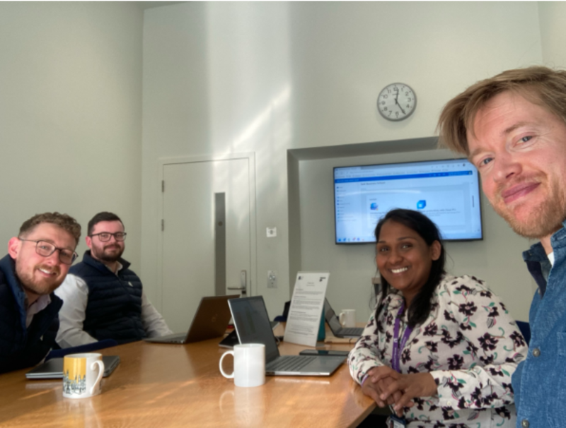 SDM team meet with Said Business school - image of 4 staff members around a table with laptops and mugs 